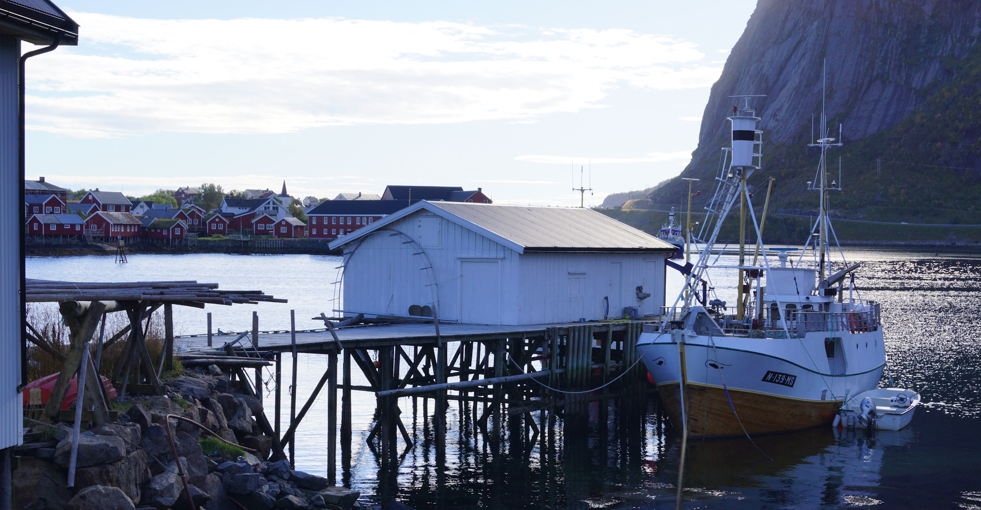 010 Fiskebåt ved kai på Andøya med Reine til venstre-Foto Geir Johansen.jpg